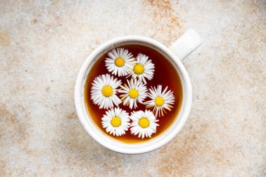 Çay, papatya çiçekleri sıcak içecek, sağlıklı yemek atıştırmalıkları masanın üzerinde fotokopi, arka plan kırsal manzarası.