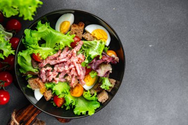 Et salatası, pastırma, yumurta, kızarmış ekmek, marul, salata soslu vinaigrette Vosges salatası Lorraine mutfağı yemek atıştırmalığı masa üzerinde fotokopi uzay yemeği arka plan kırsal manzarası