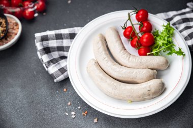 Beyaz sosis sosis dana eti, domuz eti, domuz yağı, baharat. Masada doğal kaplama yemek atıştırmalığı. Arka plandaki yiyeceklerin fotokopisi.