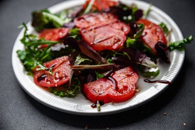 Domates dilimi salata yemeği atıştırmalığı. Arka plandaki uzay yiyeceklerinin fotokopisi. 