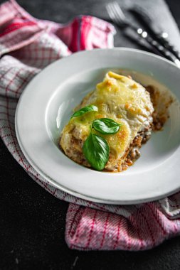 Lazanya tabağı beşamel sosu, kıyma, rendelenmiş peynir yemeği abur cuburu fotokopi masasında.