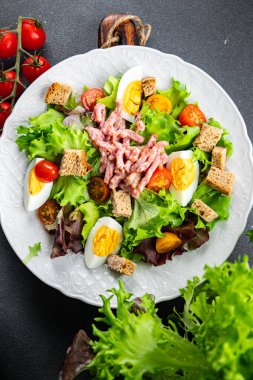 Pastırma salatası, yumurta, kızarmış ekmek, marul, salata soslu vinaigrette yemek. Masada atıştırmalıklar.
