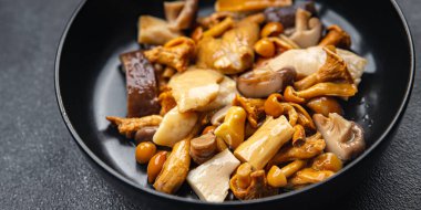 Mantar salatası karışımı beyaz mantar, mantar mantarı, chanterelle mantarı, masa üzerinde atıştırmaya hazır yiyecek fotokopisi, arka plan kırsal manzarası.