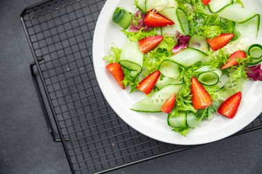 Salatalık, çilek, marul sağlıklı yemek abur cuburu masa üzerinde fotokopi uzay yemeği arka plan kırsal üst görüş keto veya paleo diyet vejetaryen ya da vejetaryen yemeği