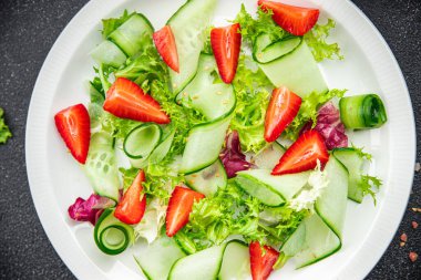 Salatalık, çilek, marul sağlıklı yemek abur cuburu masa üzerinde fotokopi uzay yemeği arka plan kırsal üst görüş keto veya paleo diyet vejetaryen ya da vejetaryen yemeği