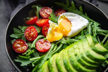 avokado salatası haşlanmış yumurta, roka, domates, yeşil salata masada sağlıklı yemek atıştırmalığı bırakır. Arka plan fotokopi, arka plan, kırsal üst görüş, vejetaryen diyet vejetaryen veya vejetaryen yemeği.