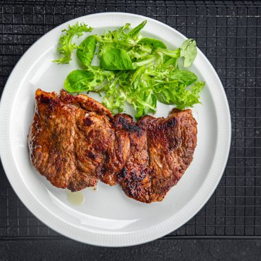 Masada domuz eti kızartması. Arka plandaki uzay yiyeceklerinin fotokopisi.