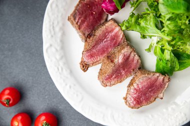 Biftek, az pişmiş taze et, kızarmış yemek. Masada atıştırmalık. Fotokopi, arka plan, sade yemek.