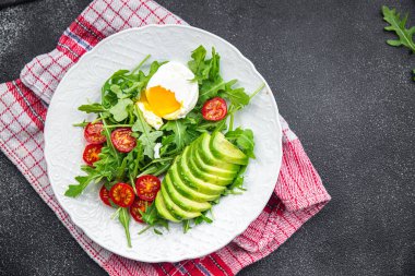Haşlanmış yumurta salatası avokado, roka, domates, yeşil salata masada sağlıklı yemek atıştırmalıkları fotokopi uzayı arka plan kırsal manzarası 