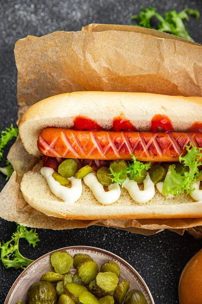 hot dog fast food sandwich sausage, gherkin, ketchup, mayonnaise meal food snack on the table copy space food background rustic top view