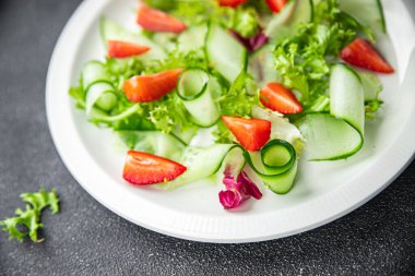 Taze salata, çilekli salatalık, salatalık, diyet diyet, abur cubur masada fotokopi, uzay yiyecekleri arka plan kırsal manzarası. 