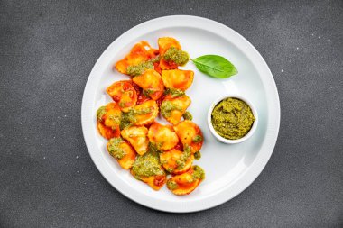 Ravioli bifteği pesto sosu, domates sosu, abur cubur. Fotokopi masasında.