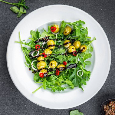 Zeytin salatası sıcak biber, yeşil karışım marul, rogula yemek atıştırmalığı fotokopi uzayı arka plan kırsal manzarası