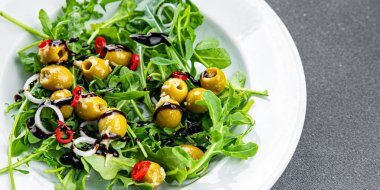Taze yeşil salata zeytin, kırmızı biber, yeşil karışım marul, roka yemeği atıştırmalığı fotokopi masasında.