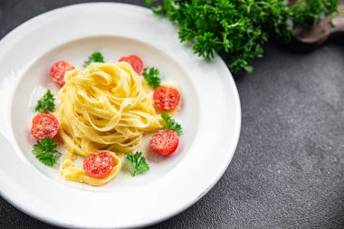 Taze domatesli makarna tagliatelle ve parmesan peynirli yemek abur cuburu fotokopi masasında.