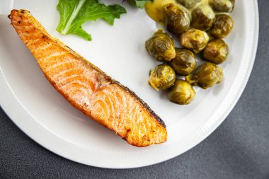 Somon kızartması ve Brüksel lahanası ikinci tabak yemek atıştırmalığı. Arka planda fotokopi alanı arka plan kırsal manzarası.