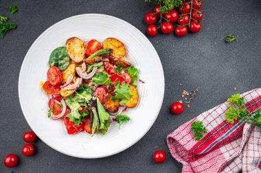 Patates salatası ve sebze fırınlanmış patates, domates, soğan, salata yaprakları, salata soslu vinaigrette sebzeler masada sağlıklı yemek atıştırmalıkları fotokopi uzayı arka plan kırsal manzarası 