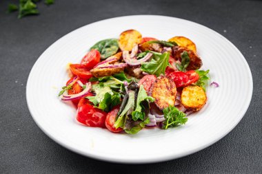 Patates salatası ve sebze fırınlanmış patates, domates, soğan, salata yaprakları, salata soslu vinaigrette sebzeler masada sağlıklı yemek atıştırmalıkları fotokopi uzayı arka plan kırsal manzarası 