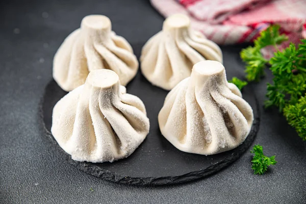 Etli khinkali yarı donmuş gıda yarı bitmiş Gürcü sebzeleri masadaki sağlıklı yemek atıştırmalıkları fotokopi alanı arka plan kırsal üst görünüm