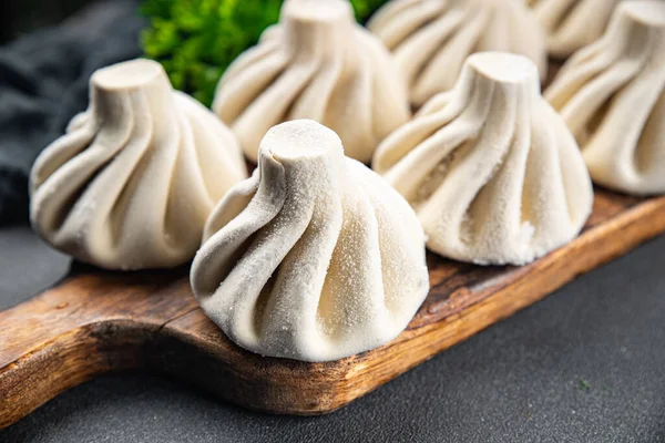 Etli khinkali yarı donmuş gıda yarı bitmiş Gürcü sebzeleri masadaki sağlıklı yemek atıştırmalıkları fotokopi alanı arka plan kırsal üst görünüm