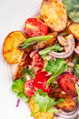 Patates salatası, sebze, patates, domates, soğan, salata yaprakları, salata soslu vinaigrette sebzeler. Masada sağlıklı yemek atıştırmalıkları. 