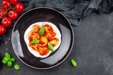 İtalyan usulü domates soslu İtalyan yemeği. Fotokopi masasında. Arka planda yemek.