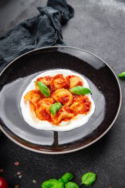 İtalyan usulü domates soslu İtalyan yemeği. Fotokopi masasında. Arka planda yemek.