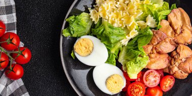 Tavuk ciğeri salatası domates, yeşil yaprak marulu, haşlanmış yumurta, farfalle makarna salatası sağlıklı yemek atıştırmalıkları yemek için hazır sofrada fotokopi uzayı arka plan kırsal manzarası