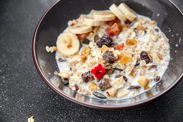 granola bowl with milk dried fruit and fresh banana tasty breakfast ready to eat healthy meal food snack on the table copy space food background rustic top view keto or paleo diet