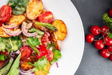 Salata, patates, sebze, patates, domates, soğan, yeşil salata yaprakları, salata sosu, salata sosu, salata soslu sebzeler, masada sağlıklı yemek atıştırmalıkları fotokopi uzayı arka plan kırsal manzarası. 