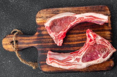 Kuzu pirzolası, çiğ et, dilimlenmiş sağlıklı aperatifler, atıştırmalıklar, fotokopi masasında.