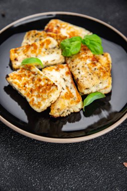Halloumi kızarmış peynir taze fesleğen yemeği masadaki fotokopi uzayı arka plan kırsal manzarası.