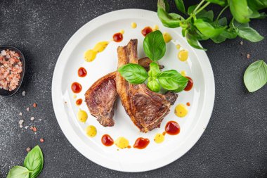 Kemiklerdeki kuzu pirzolası taze et porsiyonları sağlıklı aperatifler yemek için hazır sofrada atıştırmalıklar fotokopi uzayı arka plan kırsal manzarası