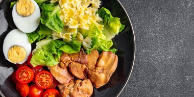 makarna salatası tavuk ciğer, domates, yeşil yaprak marul, haşlanmış yumurta, farfalle salatası yemek için hazır yemek atıştırmalığı fotokopi uzayı arka plan kırsal manzarası