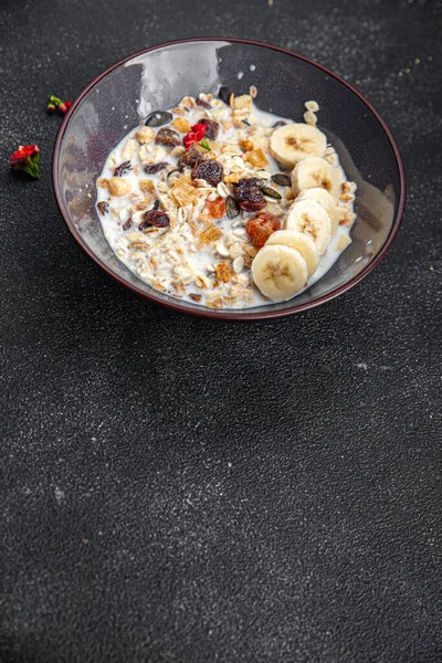 granola bowl milk, dried fruit and fresh banana tasty breakfast healthy meal food snack on the table copy space food background rustic top view