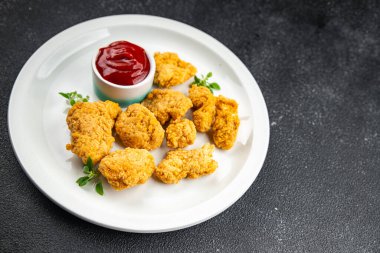 Tavuklu nugget bol yağda kızartılmış domates soslu et. Yemek için hazır. Masada atıştırmalık.