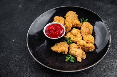 Tavuklu nugget bol yağda kızartılmış domates soslu et. Yemek için hazır. Masada atıştırmalık.