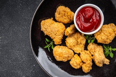 Tavuklu nugget bol yağda kızartılmış domates soslu et. Yemek için hazır. Masada atıştırmalık.