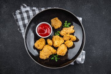 Tavuklu nugget bol yağda kızartılmış domates soslu et. Yemek için hazır. Masada atıştırmalık.