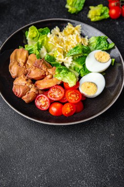 Salata tavuk ciğeri, makarna, domates, yeşil yaprak marul, haşlanmış yumurta, farfalla atıştırmalık yemek masada fotokopi uzayı arka plan kırsal manzarası