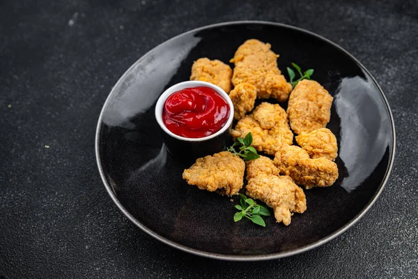 Tavuklu nugget bol yağda kızartılmış domates soslu et. Yemek için hazır. Masada atıştırmalık.
