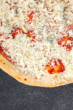 Çiğ pizza dört çeşit akmezan peyniri, gorgonzola, mozzarella, hazır aperatif aperatifler masada.