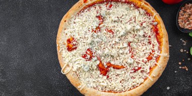 Çiğ pizza dört çeşit akmezan peyniri, gorgonzola, mozzarella, hazır aperatif aperatifler masada.