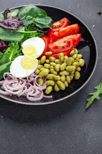 fresh salad edamame bean vegetable tomato, boiled egg meal food snack on the table copy space food background rustic top view  diet vegetarian vegan