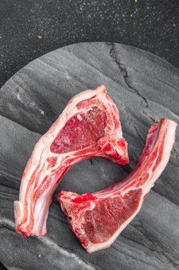 Kemik diliminde çiğ kuzu pirzolası masada atıştırmalık. Fotokopi uzayı yiyecek arka plan kırsal manzarası. 