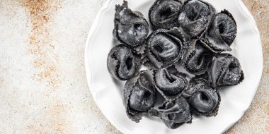 Ravioli siyah mürekkep balığı mürekkebi agnolotti taze deniz ürünleri somon balığı Pescetarian yemek aperatifleri masa üzerinde fotokopi uzay gıda arka plan kırsal üst görünüm