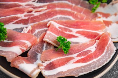 Göbek eti, domuz pastırması, taze tütsülenmiş et, masada yemek atıştırmalığı, fotokopi, arka plan, kırsal alan manzarası.