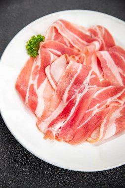 Göbek eti, domuz pastırması, taze tütsülenmiş et, masada yemek atıştırmalığı, fotokopi, arka plan, kırsal alan manzarası.