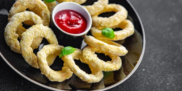 onion rings in batter deep fryer tomato sauce fast food delicious eating cooking appetizer meal food snack on the table copy space food background rustic top view