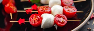 Caprese canaps mozzarella ve domates aperatifli salata şiş parmaklı, lezzetli, sağlıklı yemek aperatifli aperatifler masa üzerinde fotokopi uzay yiyecekleri arka plan kırsal üst görünüm keto veya paleo diyeti 